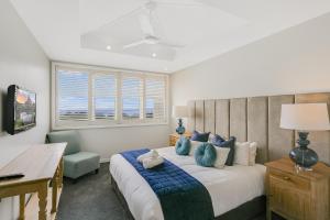 a bedroom with a large bed with blue pillows at 2BR Oceanview Penthouse @ Mantra Salt Resort by uHoliday in Kingscliff