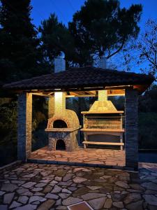 cenador con chimenea al aire libre por la noche en House in the Woods, en Karditsa