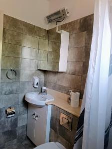 a bathroom with a sink and a toilet at Aphrodite Hills Adonis Apartment in Kouklia