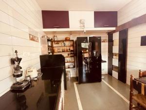 una cucina con frigorifero nero in camera di SANA VILLA a Ajgaon
