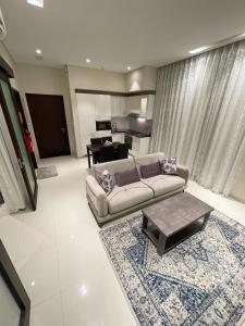 Hawana salalah Apartment Acacia في صلالة: غرفة معيشة مع أريكة وطاولة