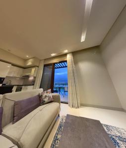 a living room with a couch and a large window at Hawana salalah Apartment Acacia in Salalah