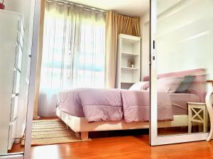 een slaapkamer met een roze bed en een spiegel bij Rama9 Cozy Apartment in Bangkok