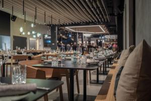 a restaurant with tables and chairs with people in the background at Aves Arosa in Arosa