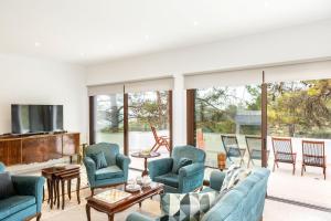 sala de estar con sillas azules y TV en Platres Forty Pine Trees Cottage en Platres