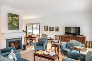 a living room with blue chairs and a fireplace at Platres Forty Pine Trees Cottage in Platres