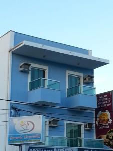 un edificio azul con 2 balcones en un lateral en Pousada Fernandes, en Arraial do Cabo