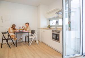 two women sitting at a table in a kitchen at EDI Astoria in Santa Cruz de Tenerife