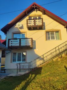 żółto-biały dom z balkonem w obiekcie Гостинний двір Матійчуків Новий w mieście Worochta