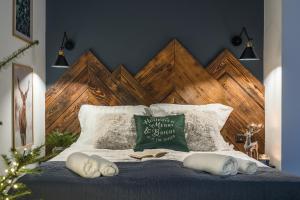 a bed with a wooden headboard and pillows on it at Rezydencja Bieszczady - Solina in Solina
