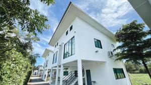 a white house with black windows at Z-Beach Resort in Ban Nong Ban Kao
