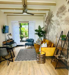 ein Wohnzimmer mit einem gelben Sofa und einem Sessel in der Unterkunft Sunset Kloof in Wilderness