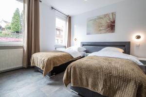 2 Betten in einem Zimmer mit Fenster in der Unterkunft Luxury Saarbrücken 4 in Saarbrücken