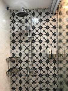 baño con una pared de azulejos en blanco y negro en MICHELIA APARTMENT, en Hanói
