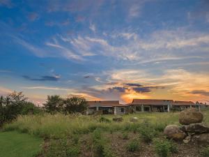 una casa in un campo con un cielo nuvoloso di The Kingdom Resort a Ledig