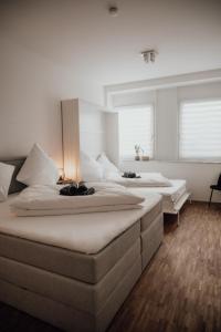 Cet hébergement comprend 2 lits dans une chambre dotée de murs blancs et de parquet. dans l'établissement JAMA - Modern&Bright, Terrasse, Freies Parken, WLAN, Große Gruppen #1, à Wurtzbourg