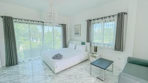 a white bedroom with a bed and a couch at Z-Beach Resort in Ban Nong Ban Kao