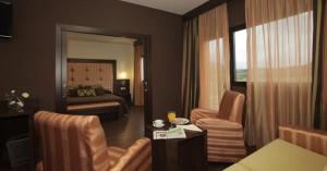 a hotel room with a living room with a bed and a living room at Complejo 24H in Monesterio