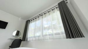 Ban Nong Ban KaoにあるZ-Beach Resortのベッドルーム1室(ベッド1台付)、窓(カーテン付)