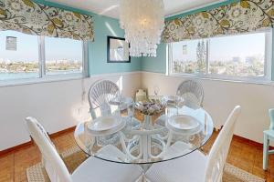uma sala de jantar com uma mesa de vidro e cadeiras em 615 - Sunset Chateau em St Pete Beach