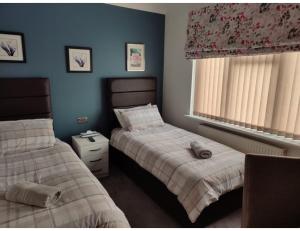 1 dormitorio con 2 camas y ventana en Room in Guest room - Apple House Wembley Twin Room, en Edgware