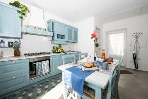 a kitchen with blue cabinets and a table with food on it at LA CASA DI SAM in Amalfi