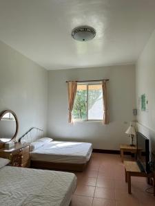 1 dormitorio con 2 camas y ventana en Green Forest Homestay en Nung-hui-ti