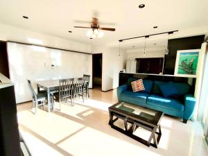 ein Wohnzimmer mit einem blauen Sofa und einem Tisch in der Unterkunft Luana Uakoko Resort 旧 EmiFull Resort in Chatan