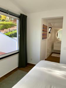 a bedroom with a bed and a large window at Marti Watersports in Martinchel