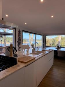 a kitchen with a sink and two large windows at Marti Watersports in Martinchel