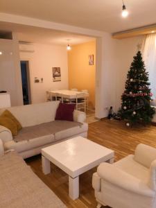 een woonkamer met een kerstboom en een bank bij 3 A LUX Apartmani in Podgorica