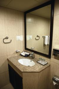uma casa de banho com um lavatório e um espelho grande em Hotel Hillview Islamabad em Islamabad