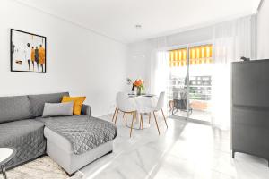 ein Wohnzimmer mit einem Sofa und einem Tisch in der Unterkunft lovely sunny apartment with shared pool and private parking in Torrevieja