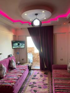 Pokój z 2 łóżkami i pokój z różowym oświetleniem w obiekcie Family Condo With Panoramic Sea View 1 w Aleksandrii