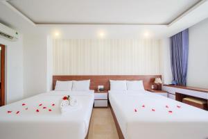 two beds in a hotel room with roses on them at Ha Nhung Hotel Nha Trang in Nha Trang