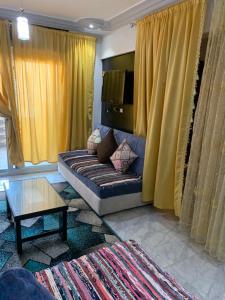 uma sala de estar com cortinas amarelas e um sofá em Family Condo With Panoramic Sea View 2 em Alexandria