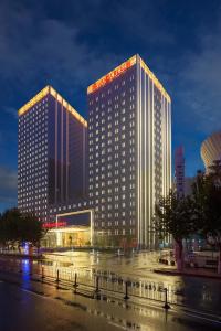 two tall buildings in a city at night at Wanda Realm Jining in Jining
