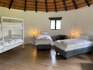a bedroom with two bunk beds and a chair at Dieu Donne Cottage in Underberg