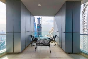 a balcony with a table and chairs in a building at Maison Privee - High-Floor Trendy Apt with Marina, Palm & Ocean Vws in Dubai