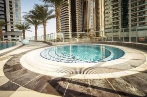 杜拜的住宿－Maison Privee - High-Floor Trendy Apt with Marina, Palm & Ocean Vws，一座高楼建筑中的大型游泳池