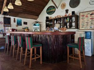 a bar with green chairs and a wooden counter at Moheli Laka Lodge in Mohéli