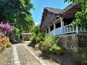 une maison avec un chemin en pierre et des fleurs dans l'établissement Moheli Laka Lodge, à Mohéli