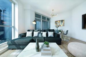 a living room with a couch and a table at Maison Privee - High-Floor Trendy Apt with Marina, Palm & Ocean Vws in Dubai