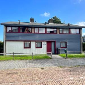 a large house with a red and white at Wijk de Brabander 58 in Cadzand