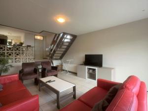 een woonkamer met een rode bank en een tafel bij Wijk de Brabander 58 in Cadzand