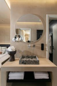 y baño con lavabo y espejo. en Eden Beachfront Residences & Suites en Kastraki