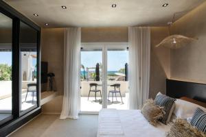 a bedroom with a bed and a view of the ocean at Eden Beachfront Residences & Suites in Kastraki