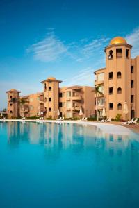 a large swimming pool in front of some buildings at Marom Port Said Resort in Port Said