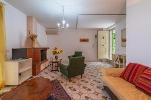 - un salon avec un canapé et une cheminée dans l'établissement Eremo degli Oleandri with pool, à Augusta