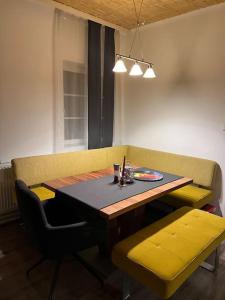 une table de salle à manger avec deux chaises jaunes et une table et sidx sidx dans l'établissement Modernes Haus nähe Schloss Ulmerfeld, à Ulmerfeld